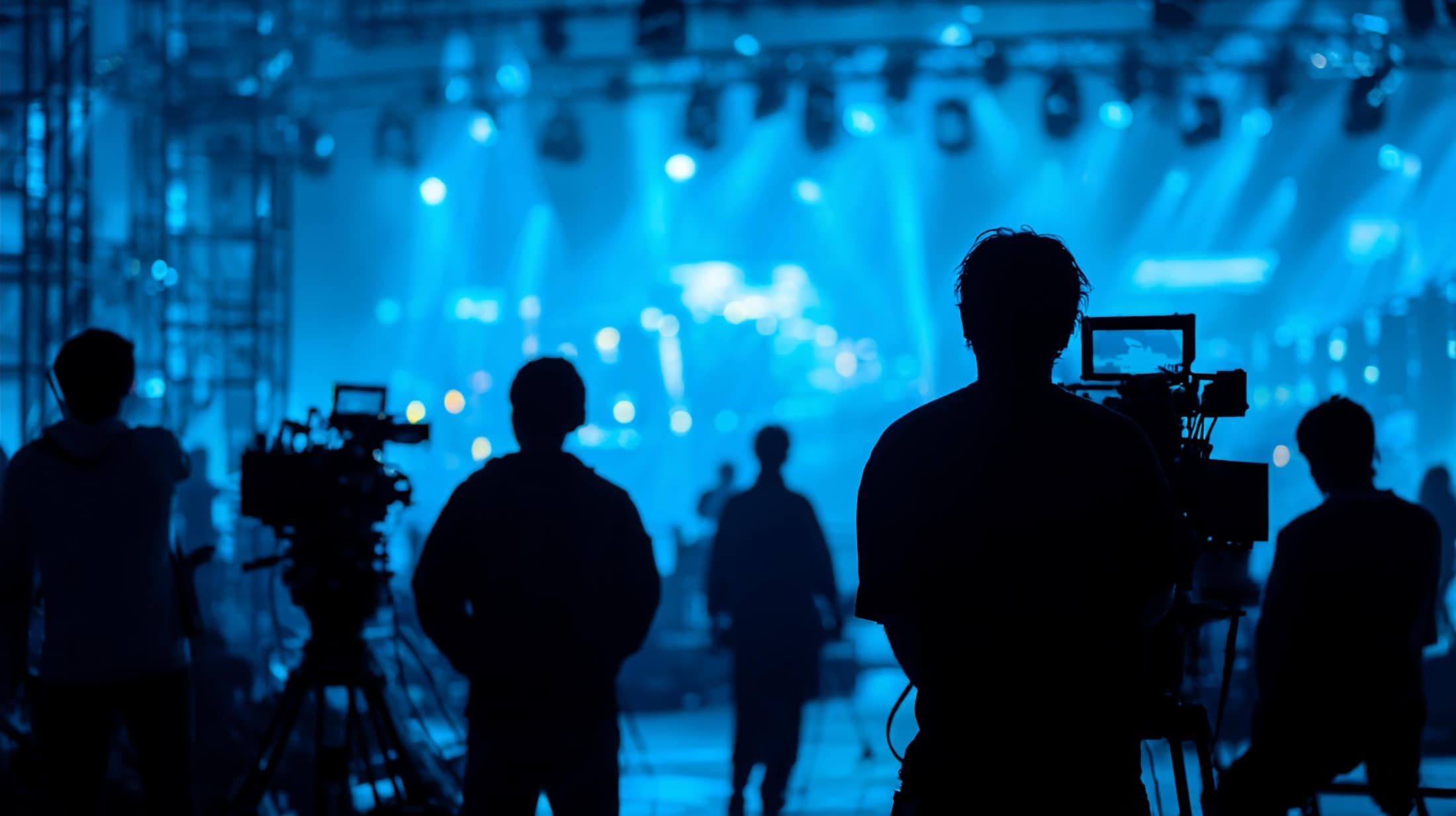 An event production crew silhouetted against the stage lights of a live show