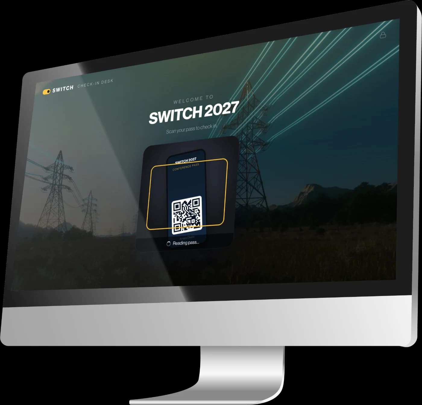 The SWITCH 2027 check-in desk on a desktop computer at the entrance, in self-service mode, reading a pass held up to the camera.
